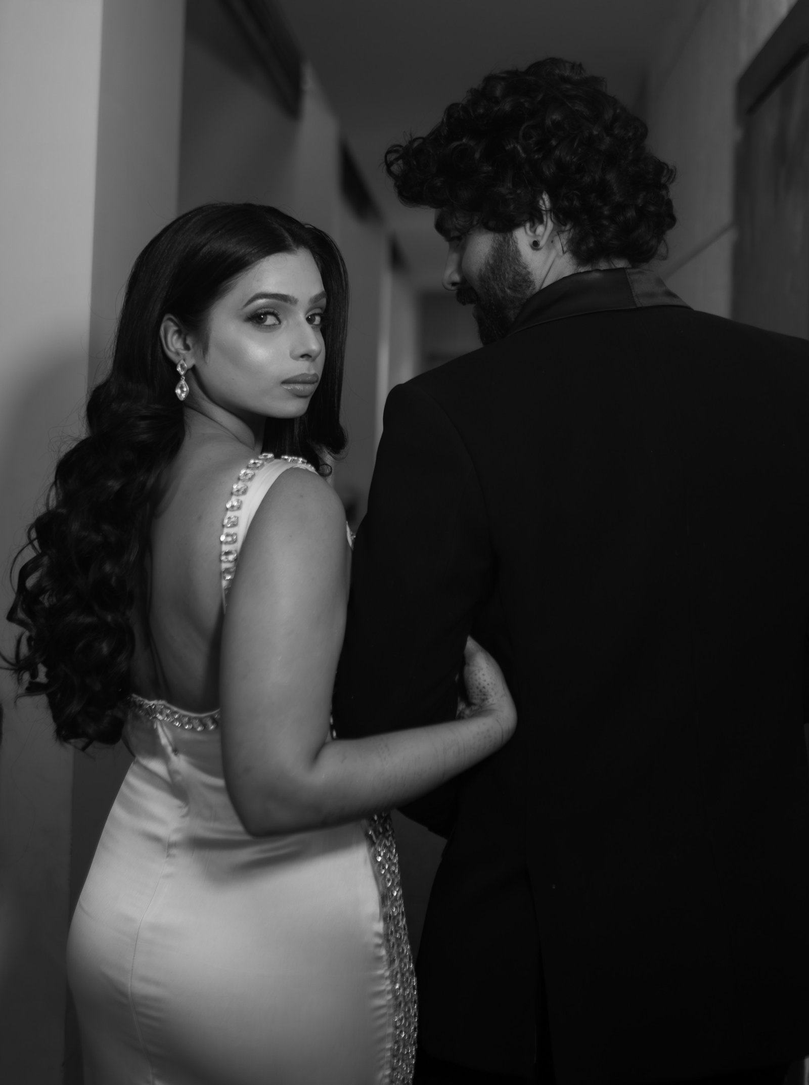A couple photographed in black and white, the bride looking back over her shoulder