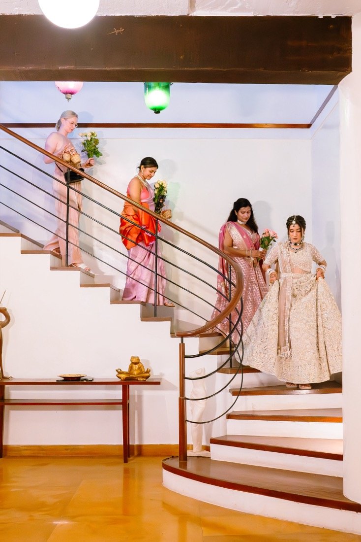 A bride and her bridesmaids descending a staircase