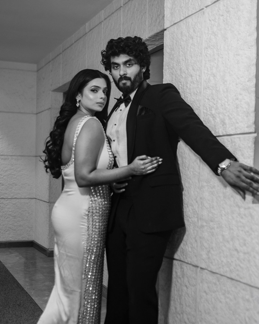 A couple in a sequinned gown and tuxedo, in black and white