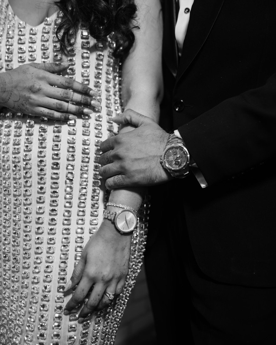 The couple's hands and wristwatches, in black and white