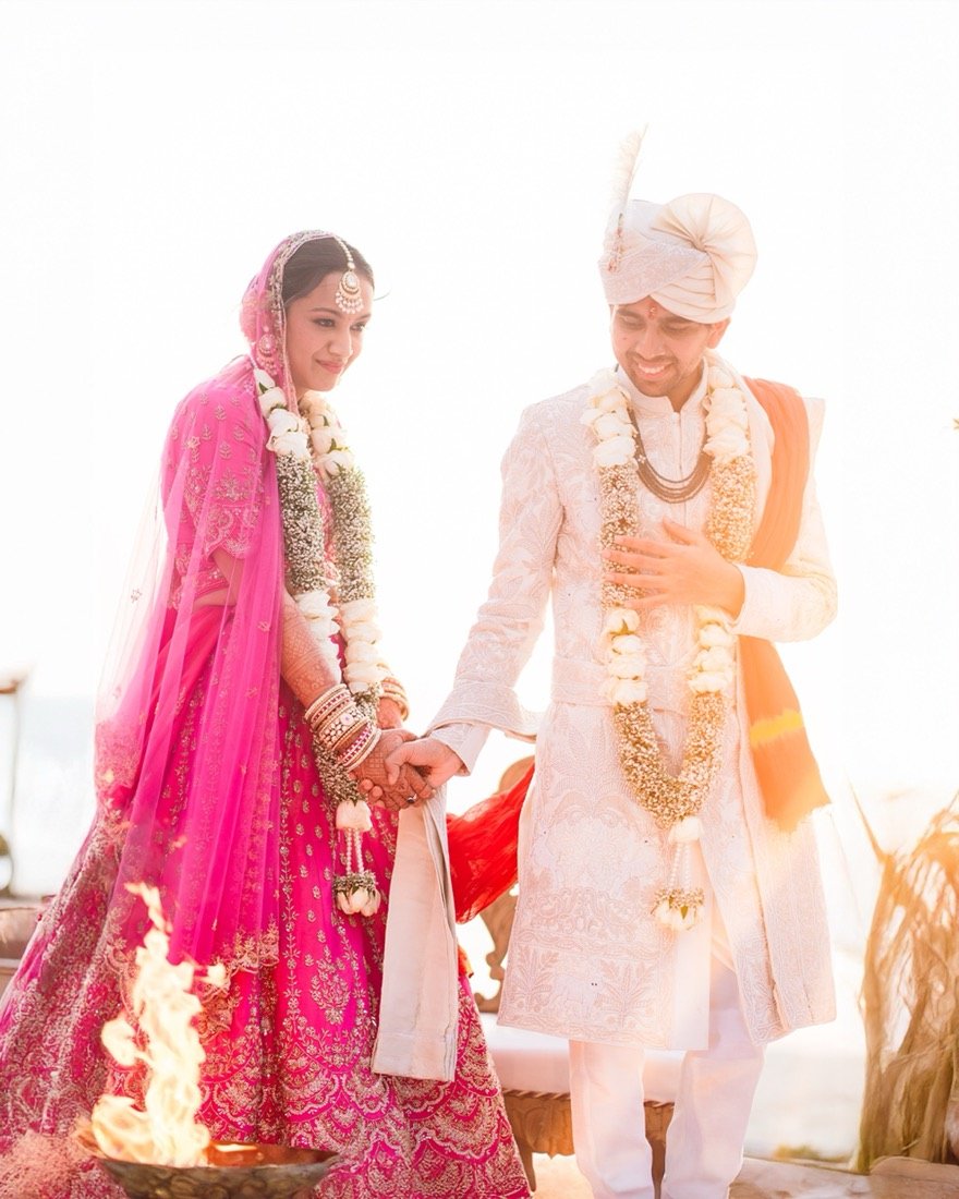 A bride and groom in pink and ivory circling the sacred fire