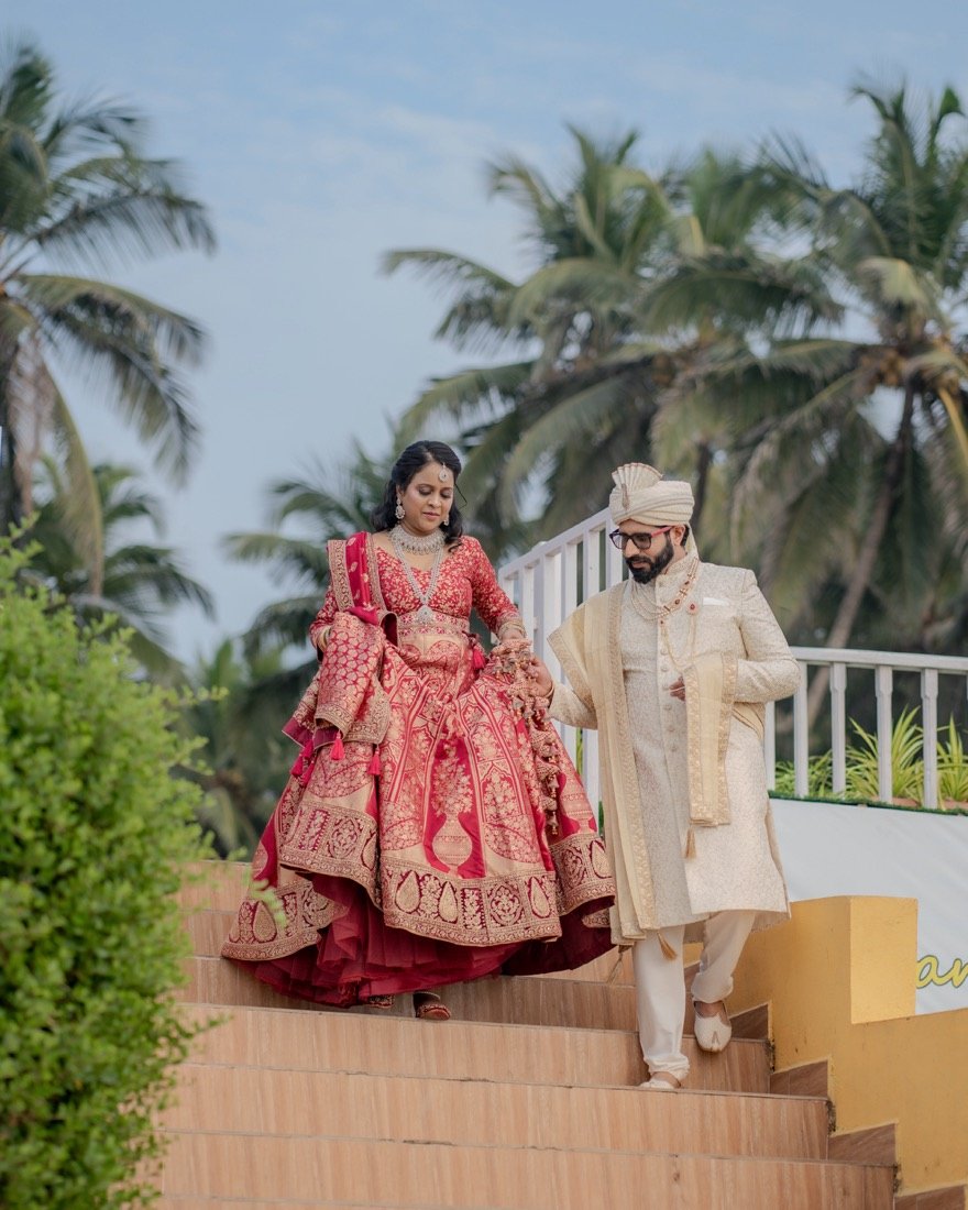 A couple walking hand in hand down palm-lined steps
