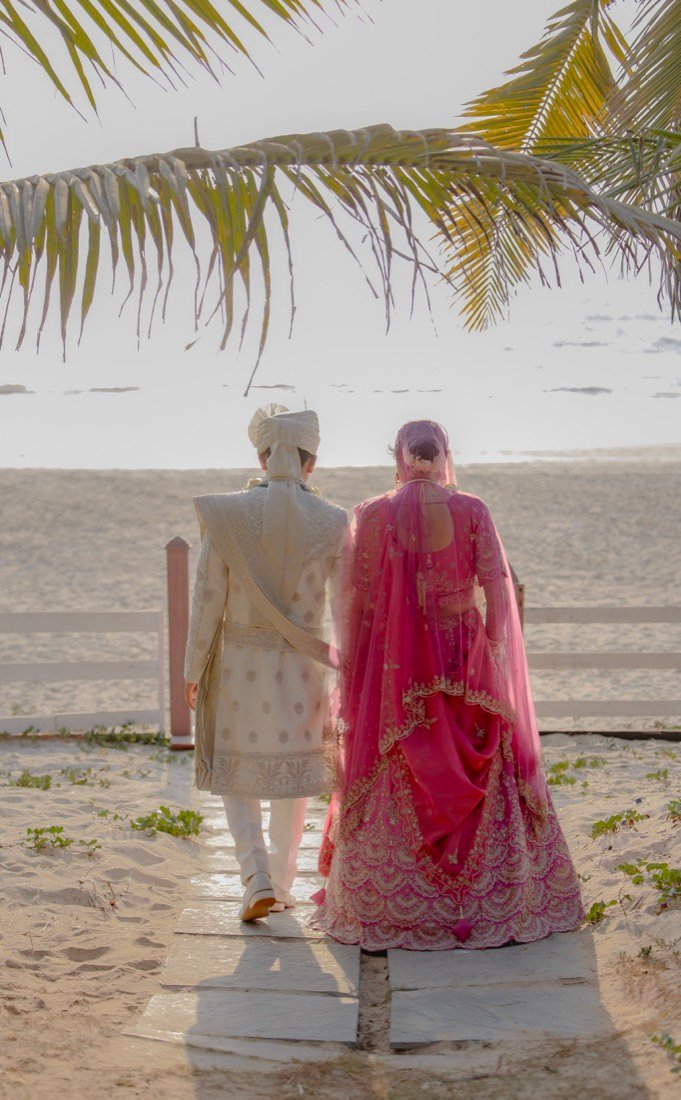 The garland exchange beneath the flowered mandap, petals falling