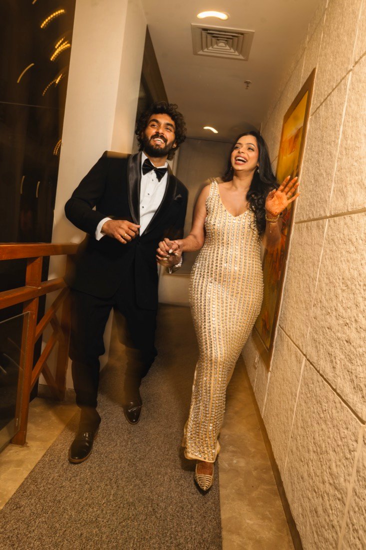Shweta and Binoy laughing as they walk the corridor