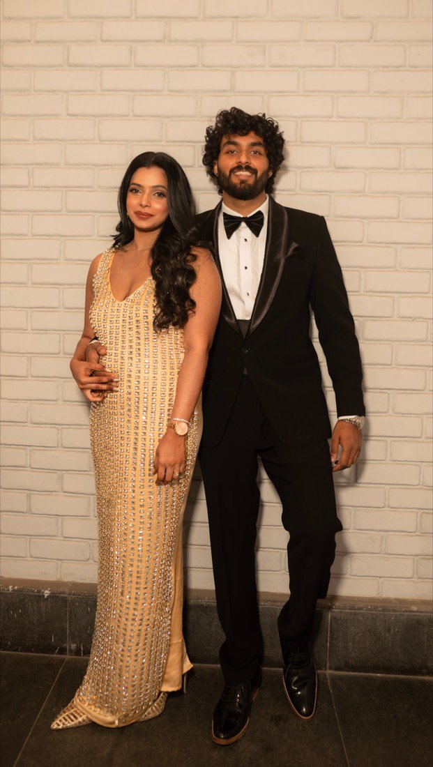 Shweta and Binoy against the white brick wall